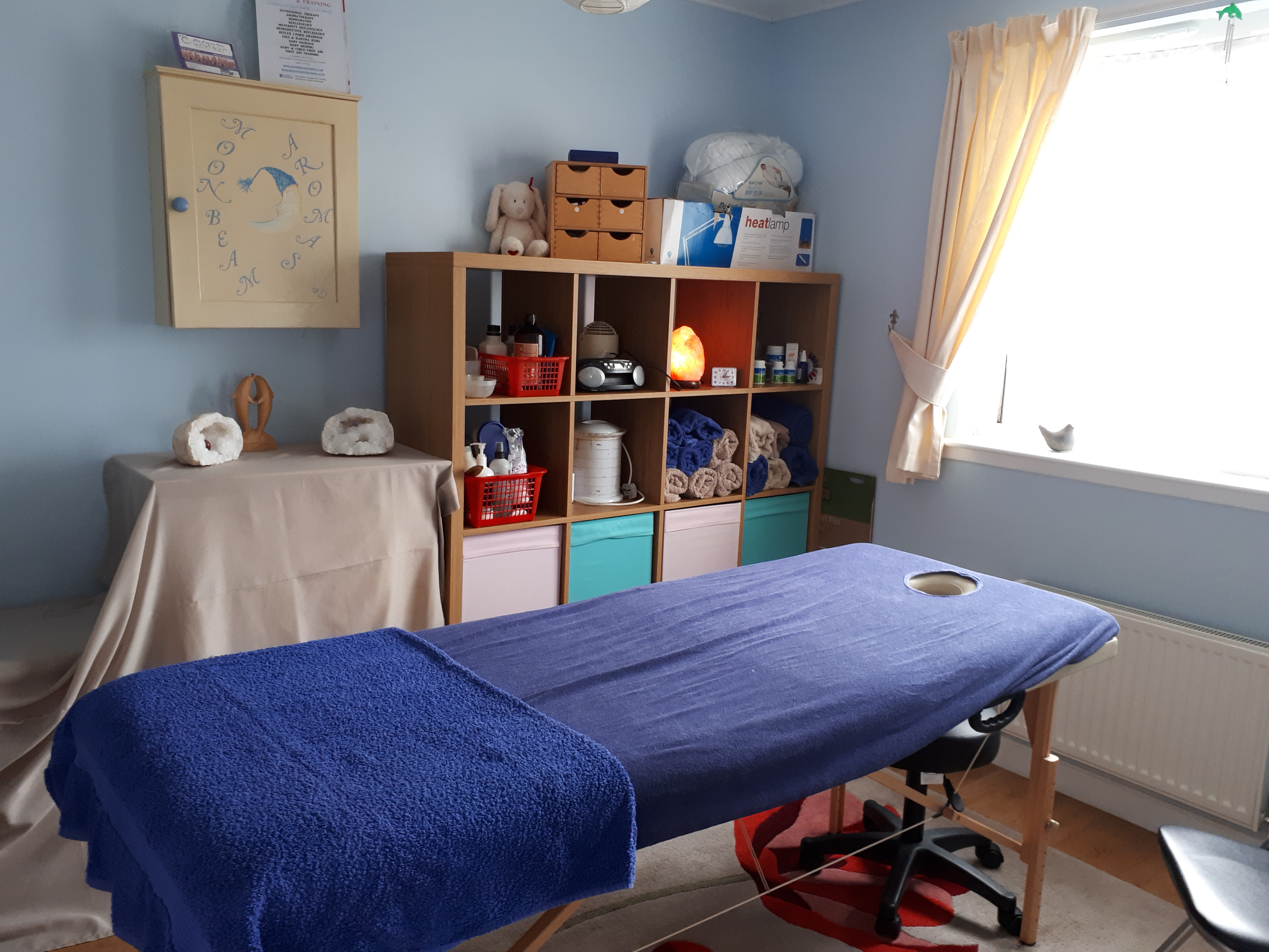 for blog - treatment room set up for a client, massage couch with blue covers on